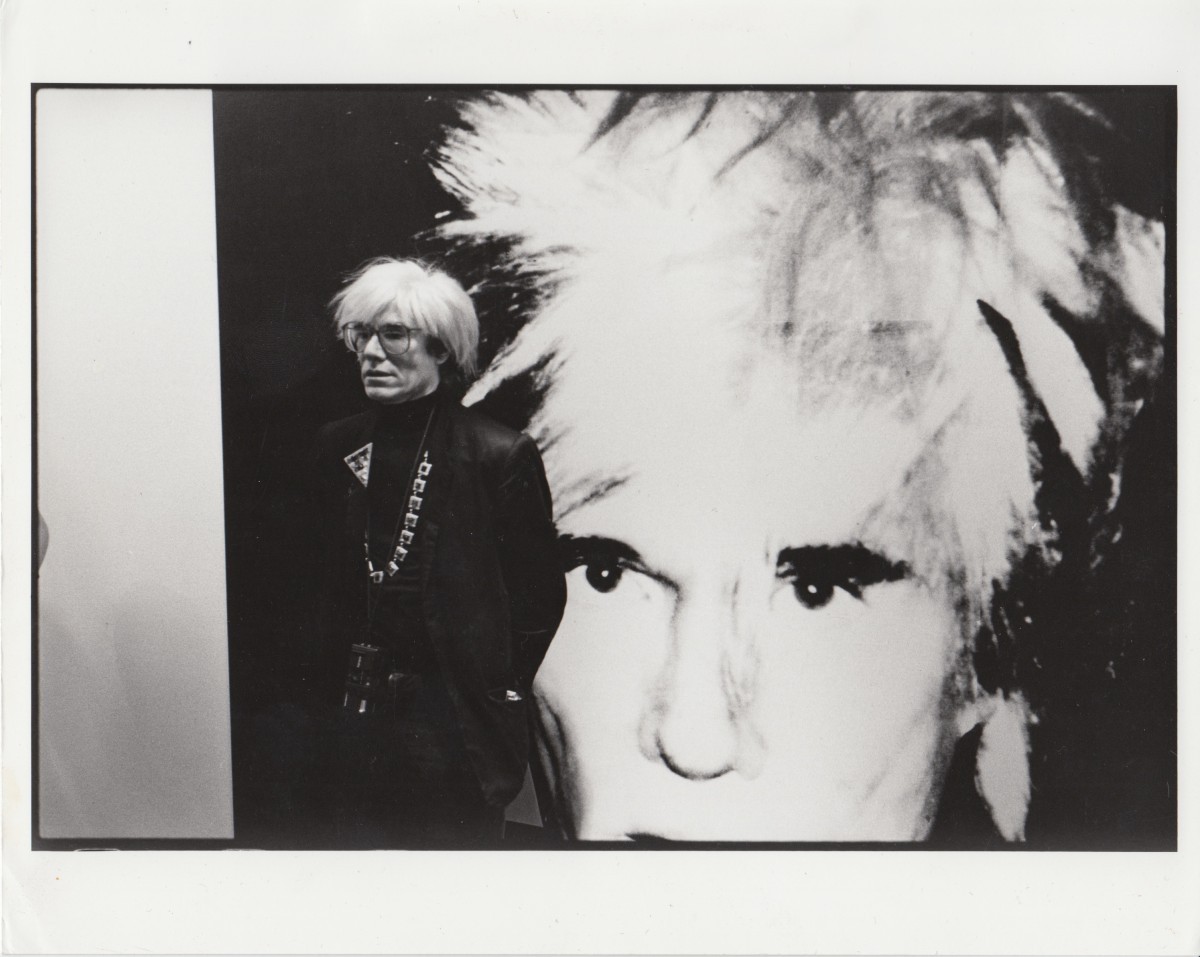 ANDY WARHOL WITH ONE OF HIS SELF-PORTRAITS